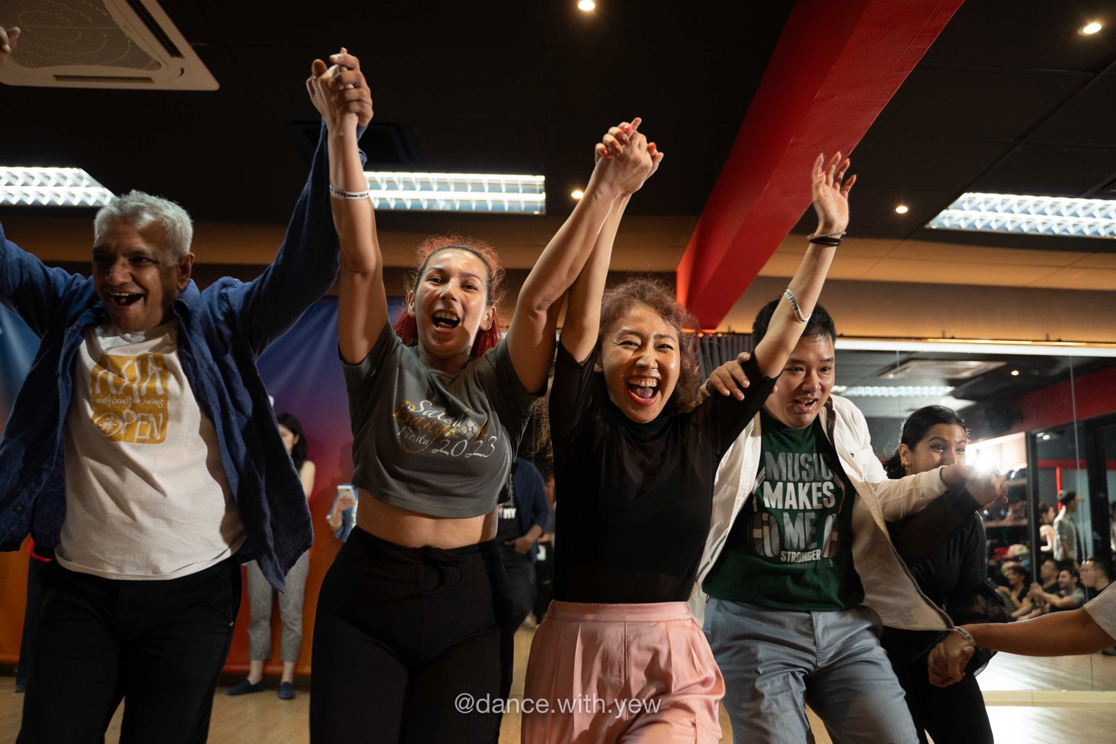 Friends cheer with raised arms beside the dance floor at MY Swing 2024.