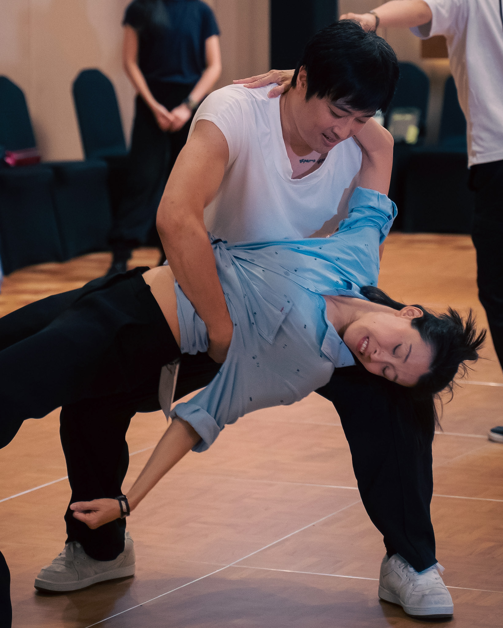 Two competitors perform a dramatic supported dip.