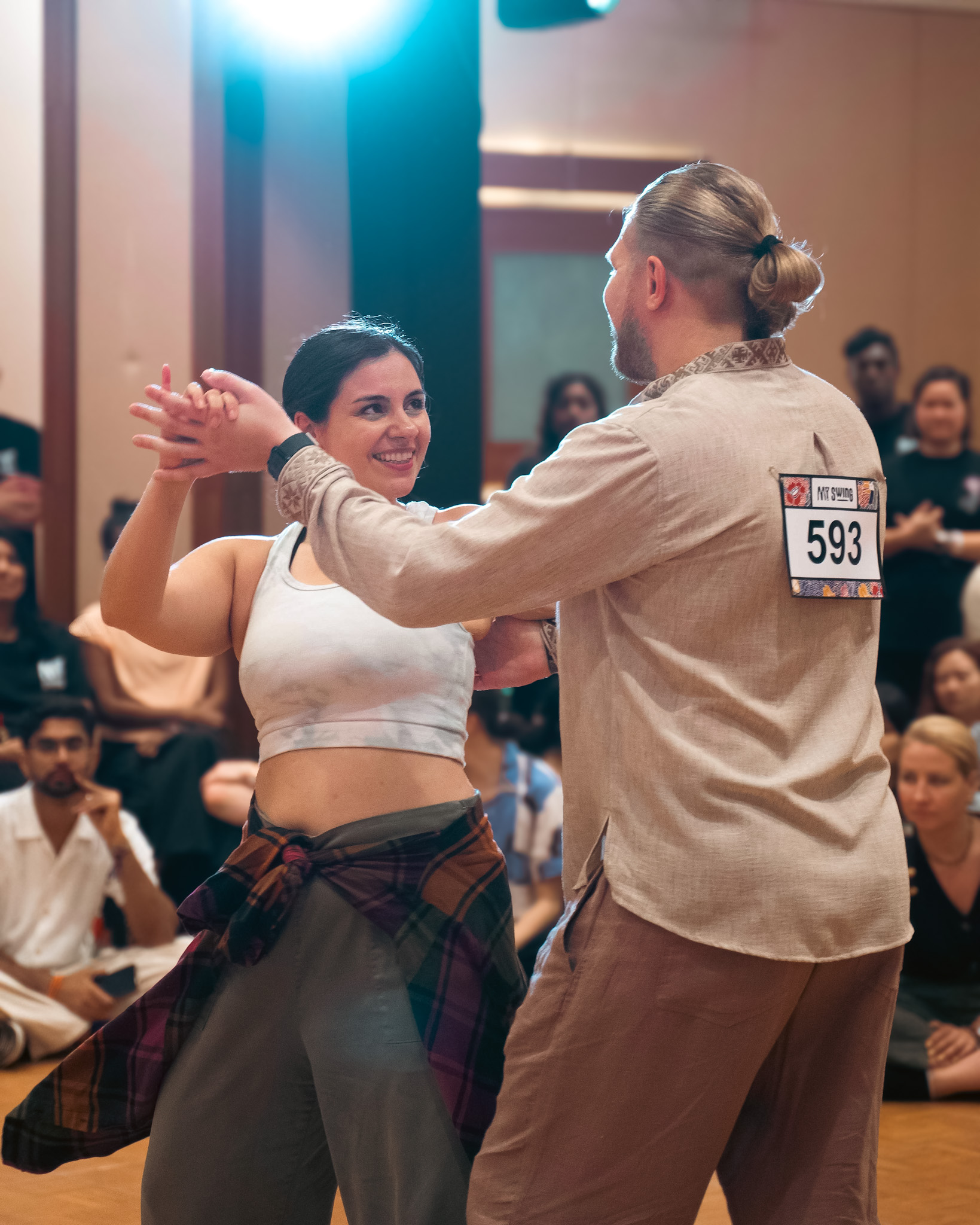 A couple dances with their hands connected before the audience.