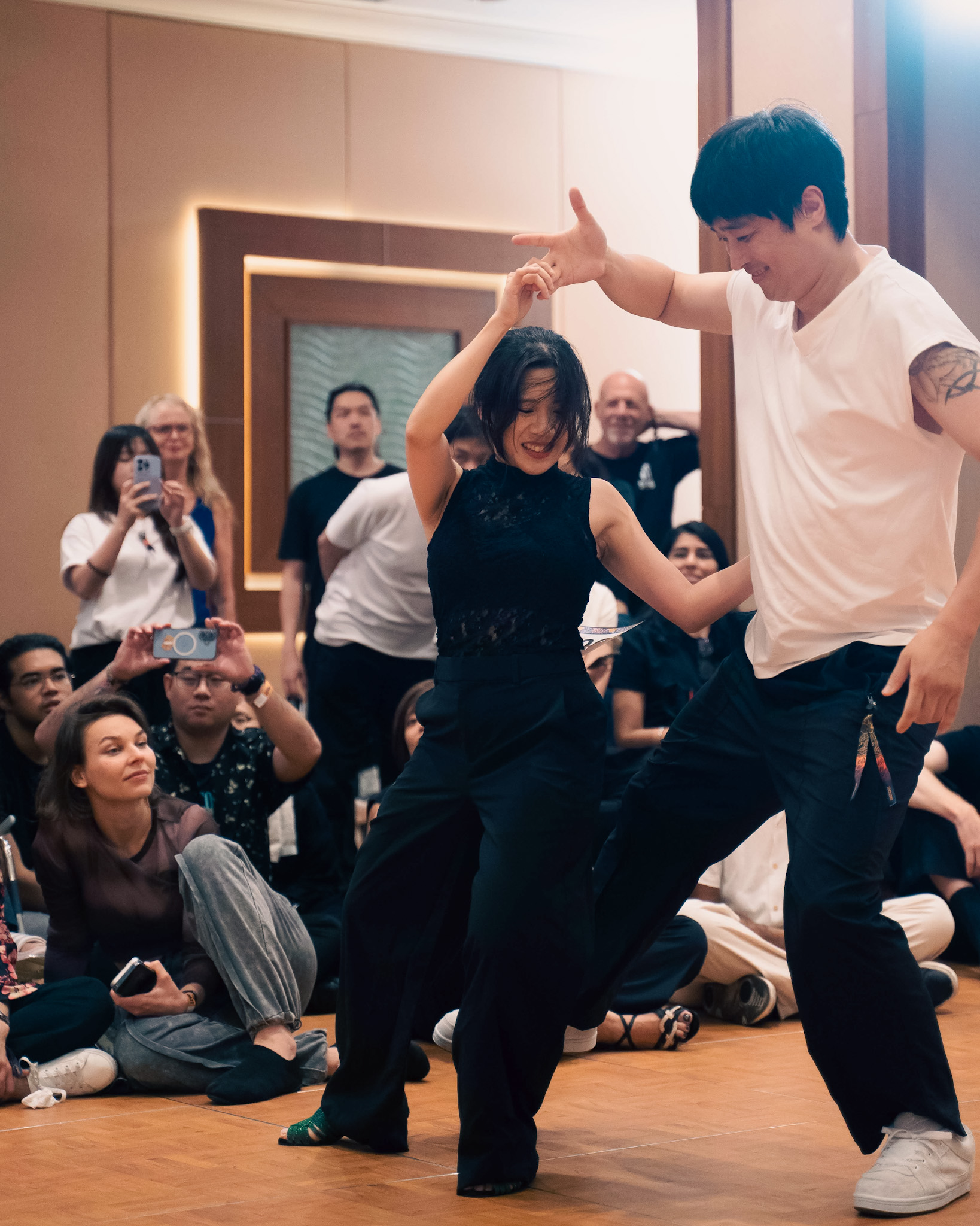 A pair performs a turn in front of a seated crowd.