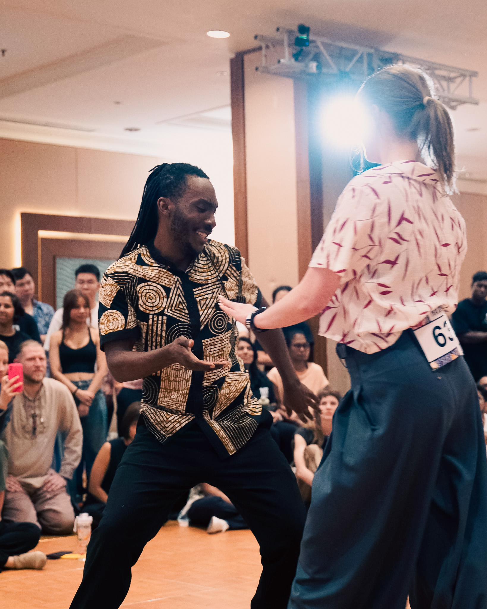 Competition partners share a playful exchange on the floor.