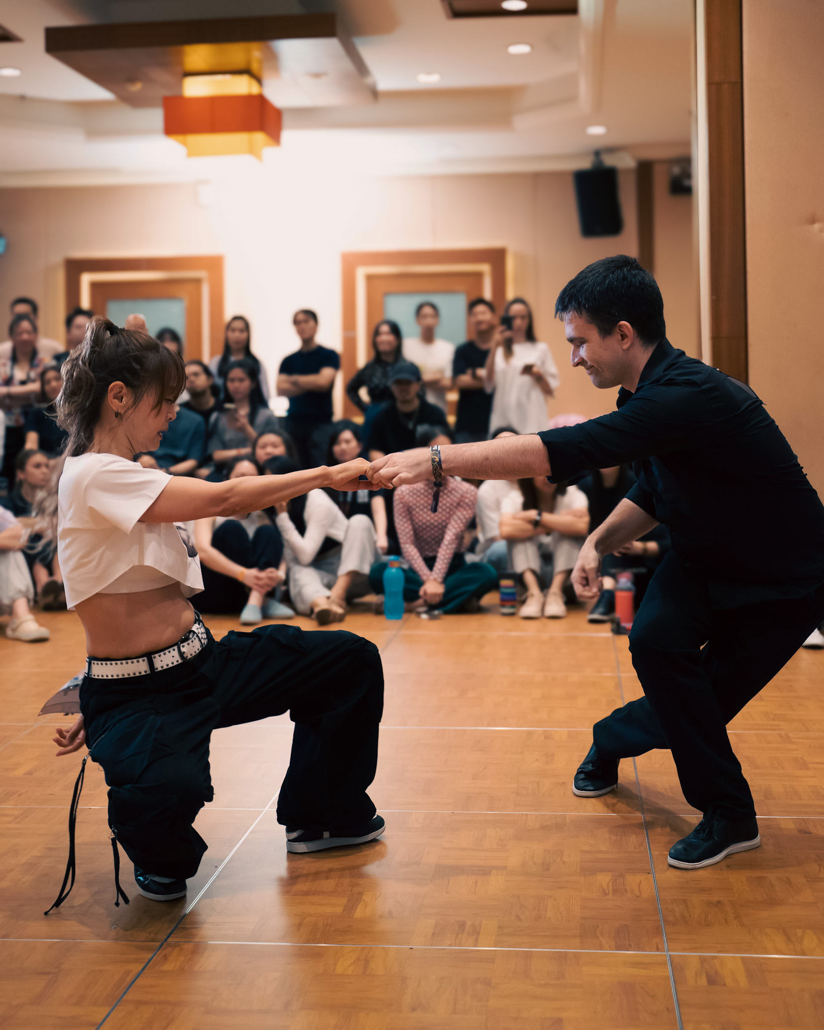 A dancer drops into a low pose while maintaining partner connection.
