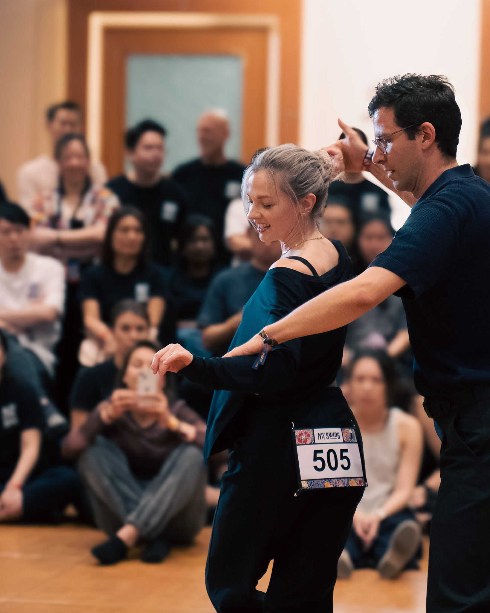 A smiling pair leans into a synchronized move.