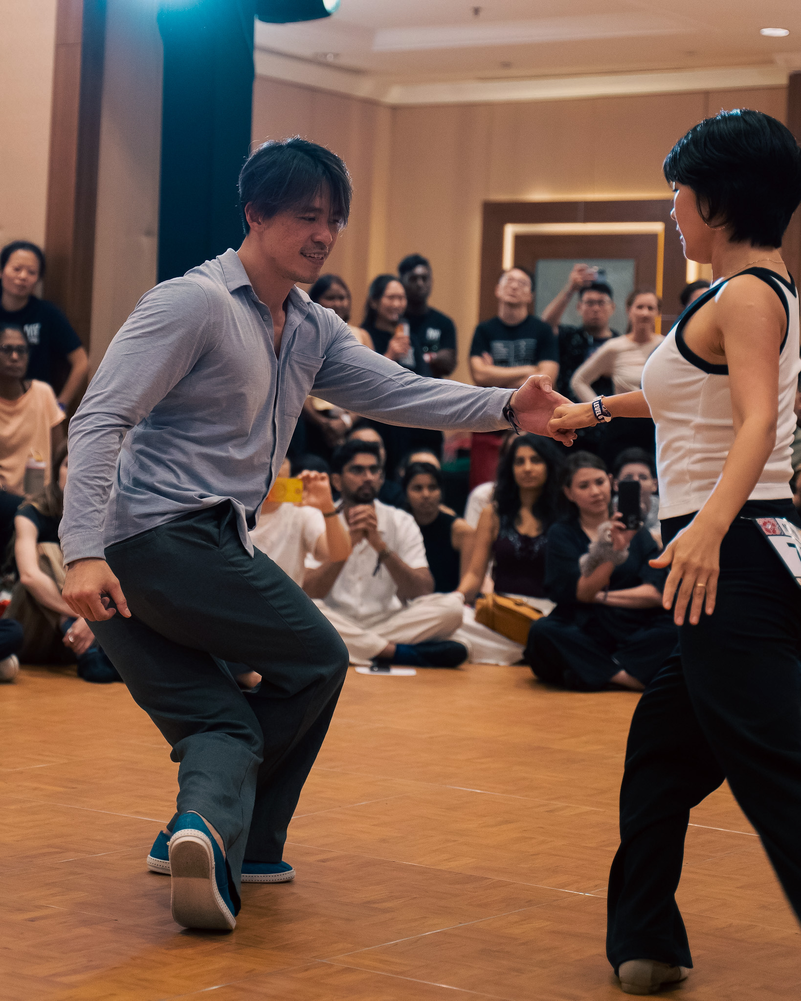 Two competitors exchange an easy smile mid dance.