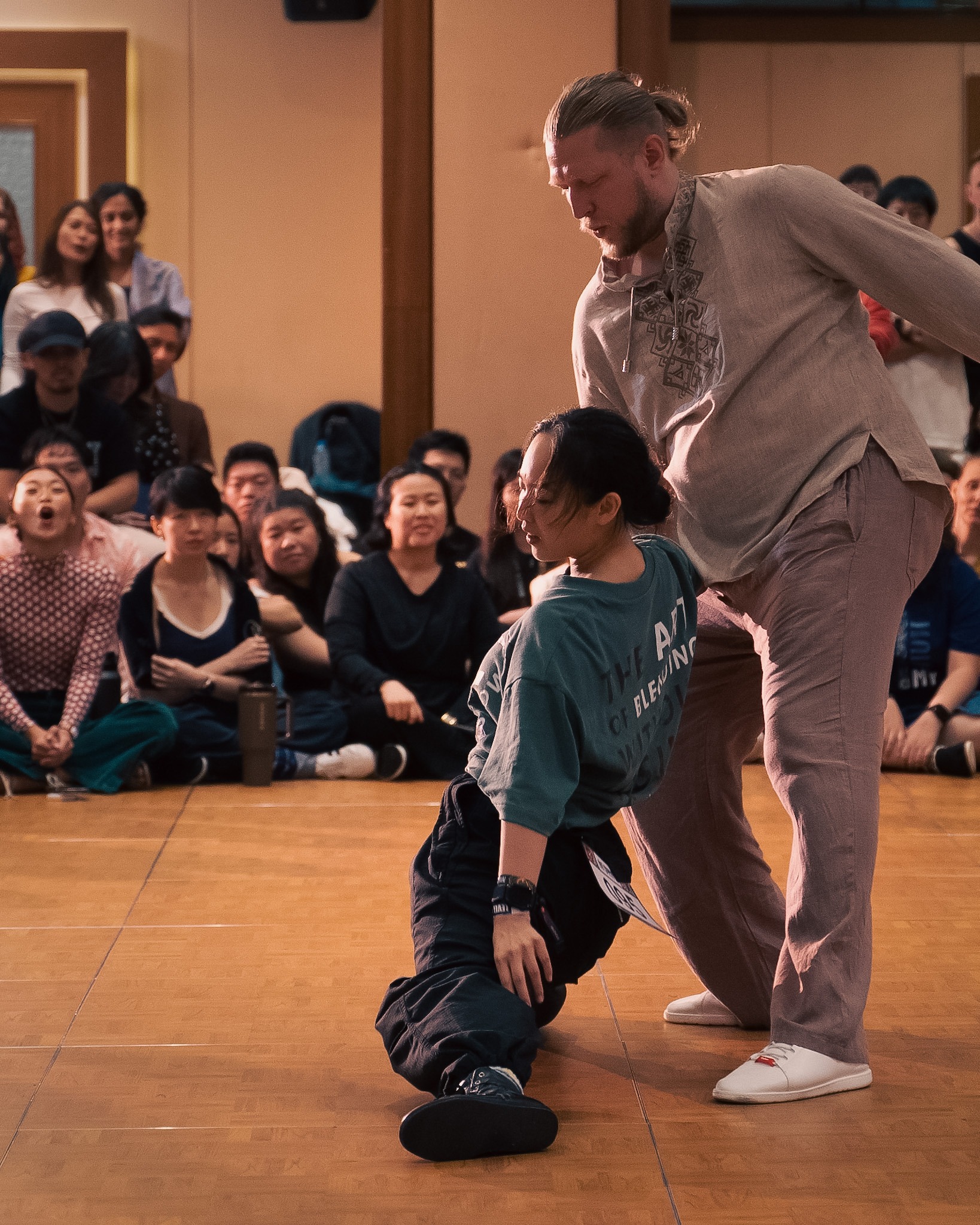A partner supports a playful low pose on the floor.
