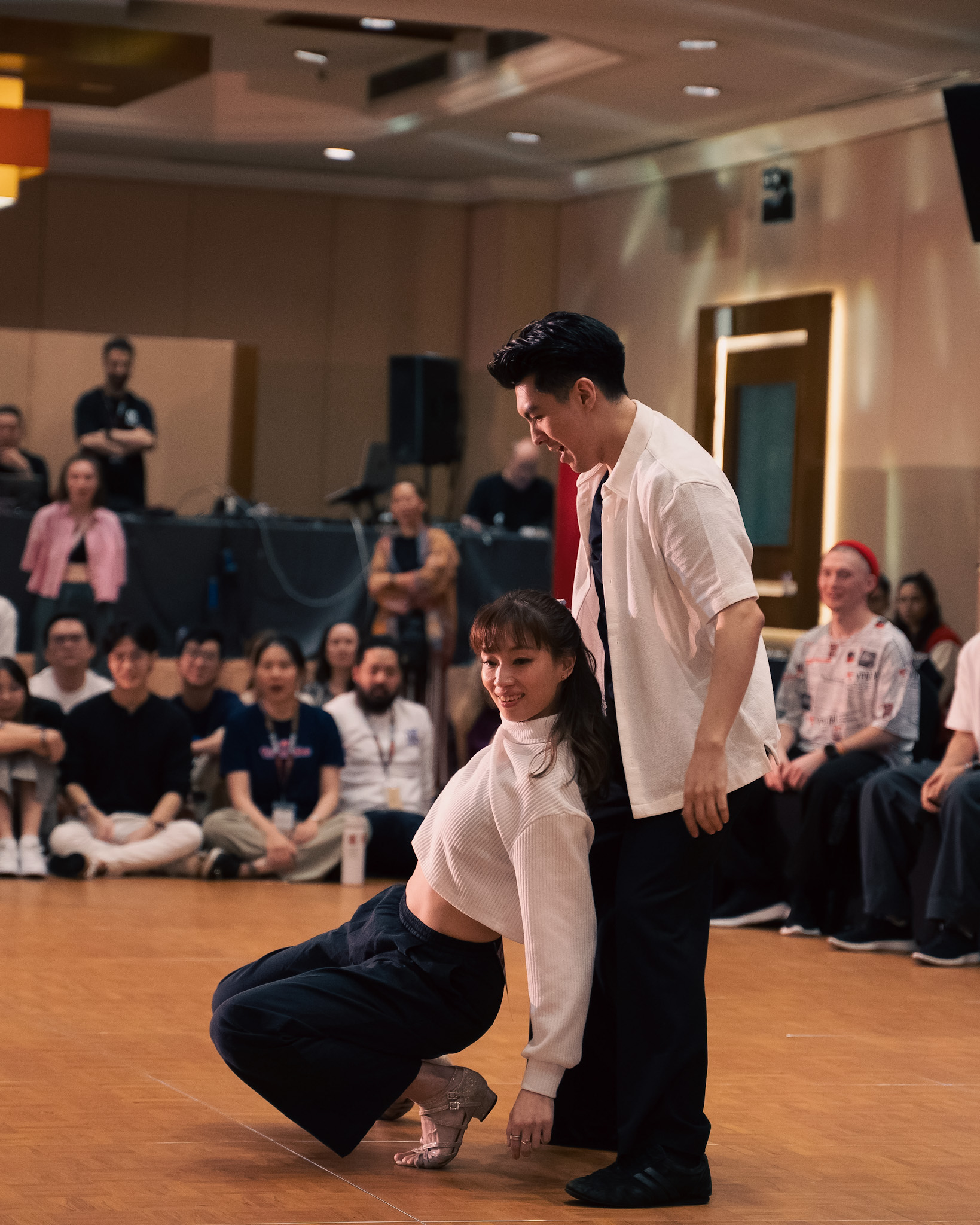A dancer lifts their partner's hand into a turn.