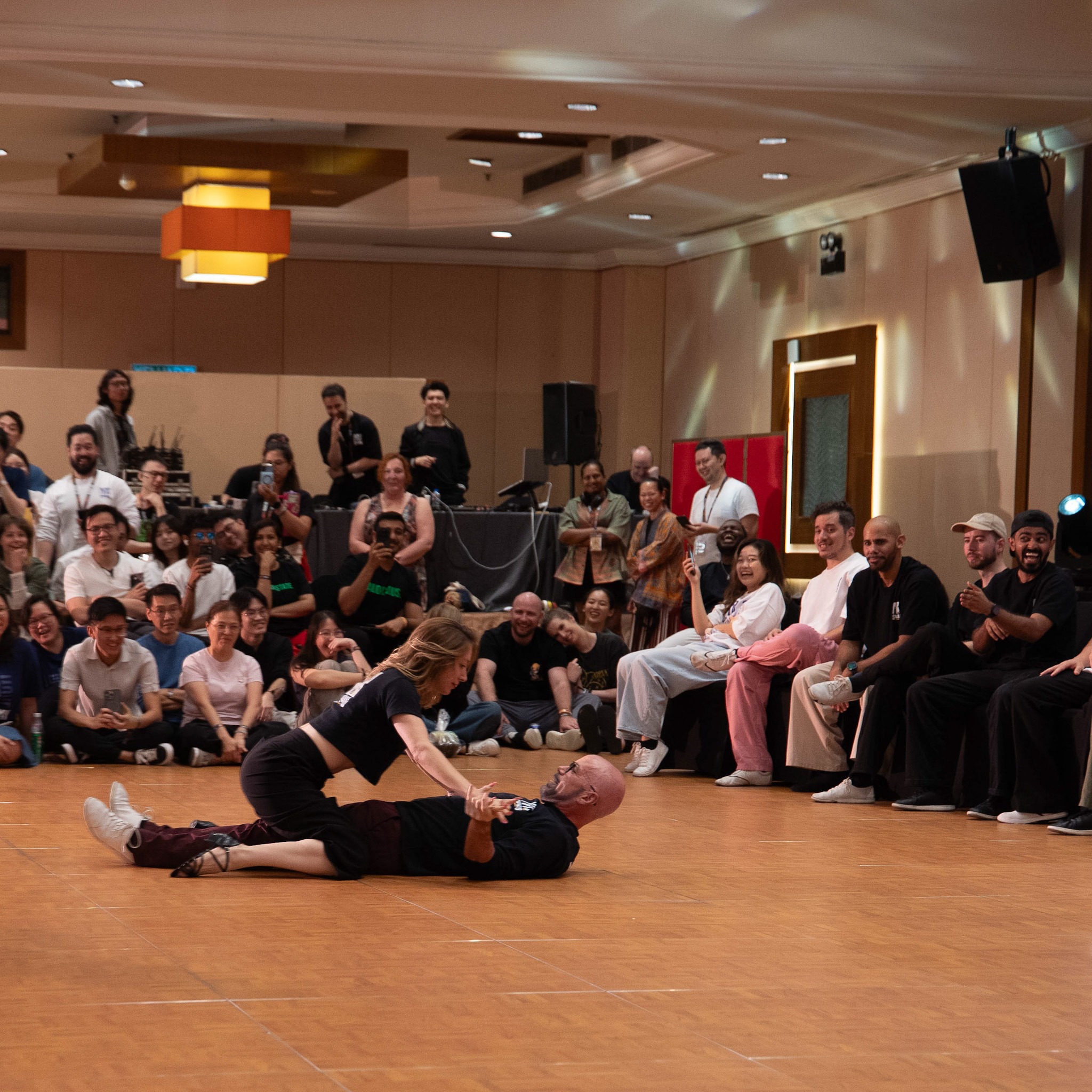 Performers execute a dramatic floor move before the crowd.
