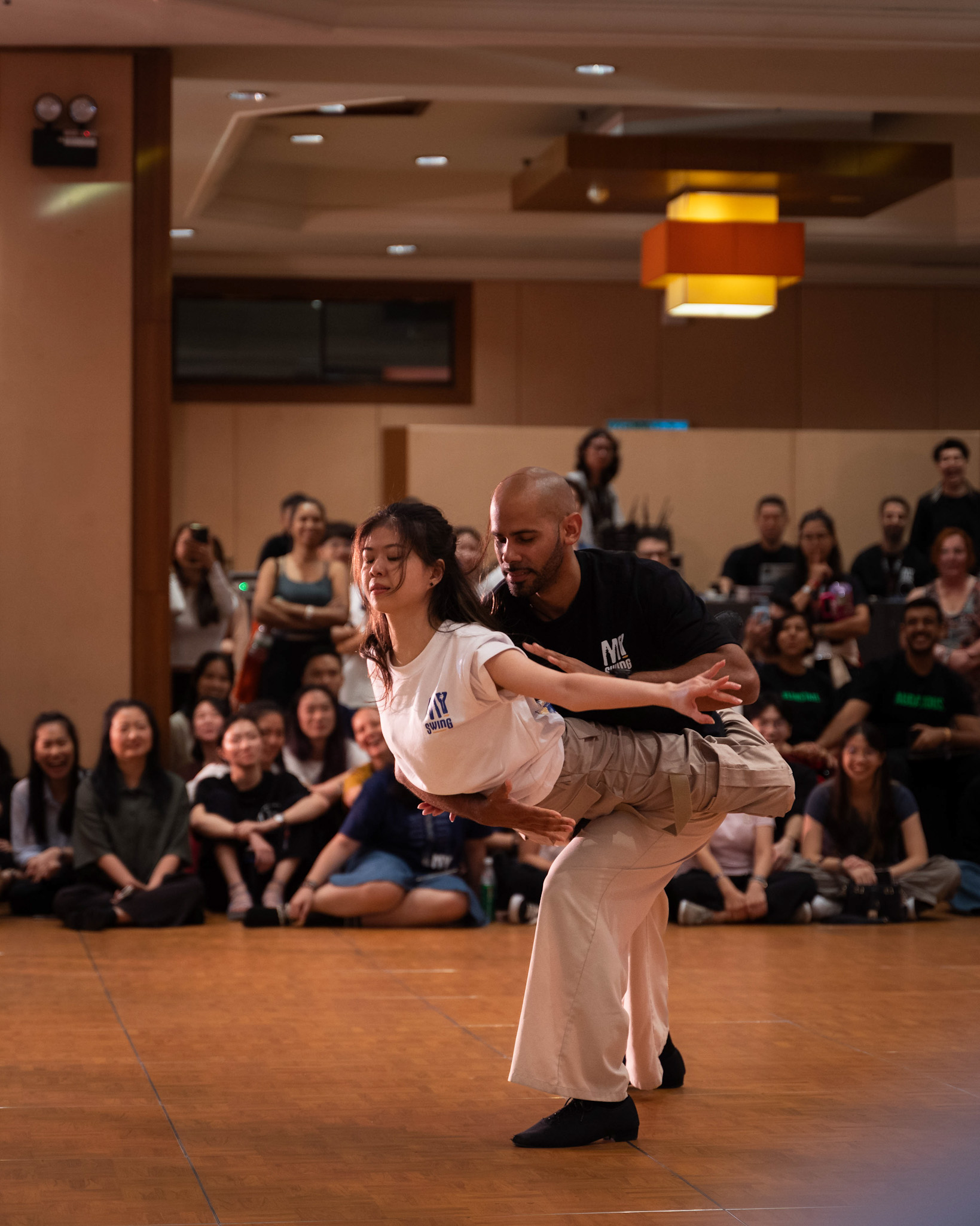 A performer lifts their partner in front of the crowd.
