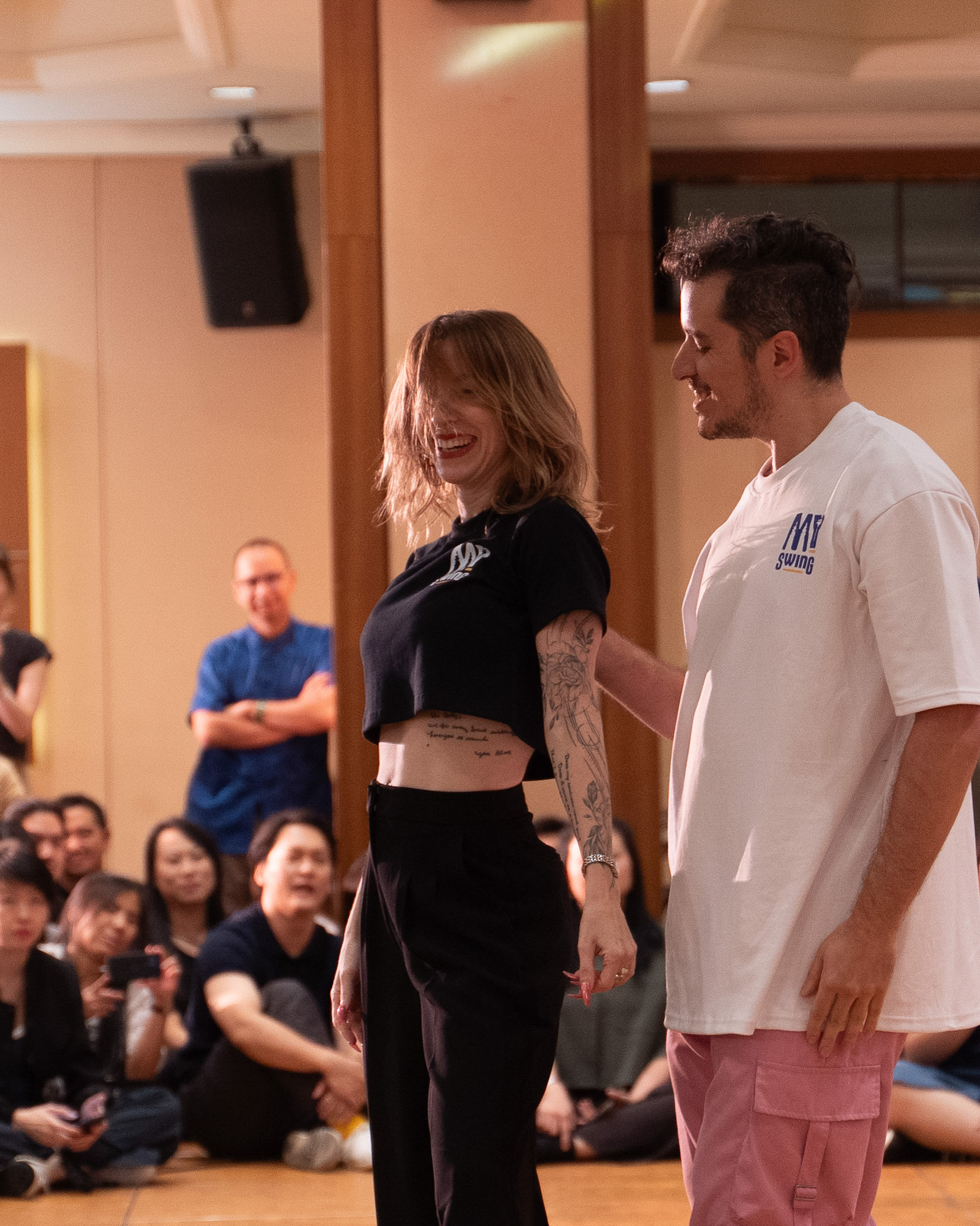 Two Pro Invitational dancers share a smile on the floor.