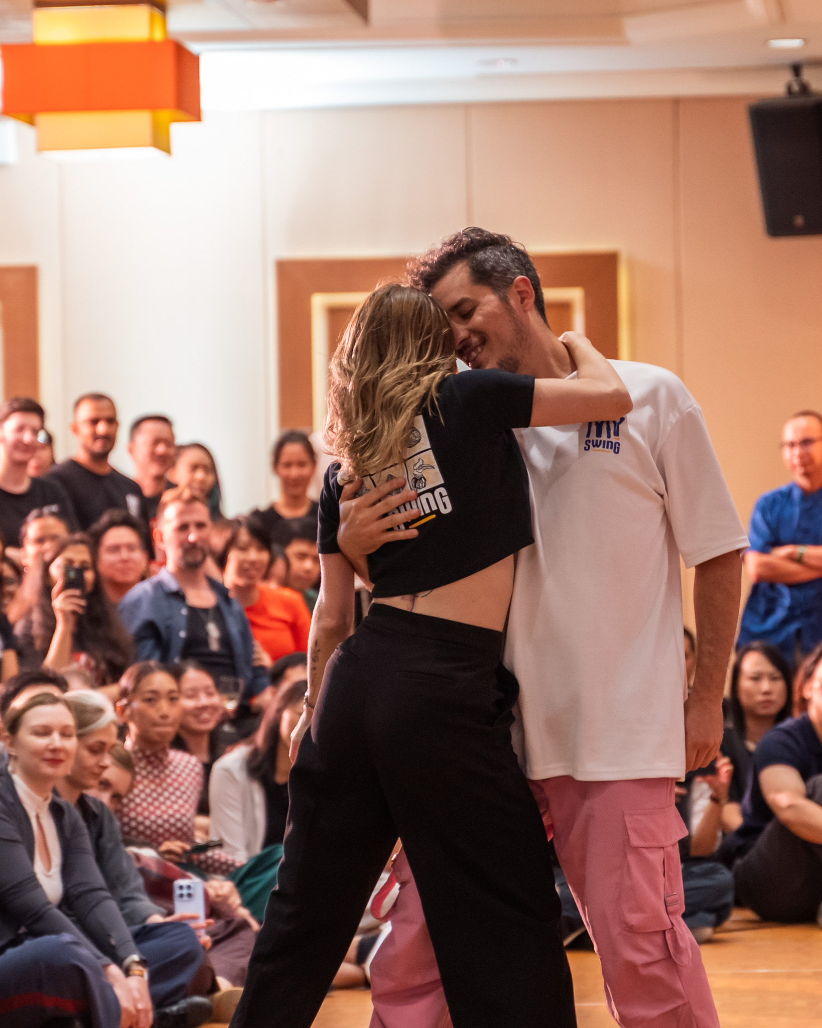 Pro Invitational partners embrace as the audience applauds.