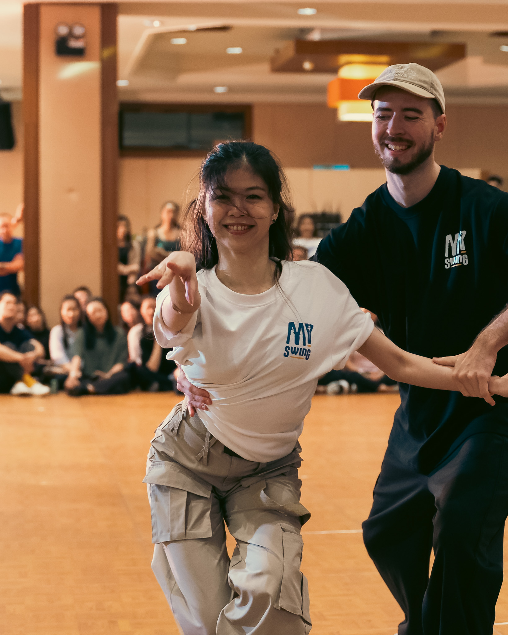 A smiling Pro Invitational pair dances toward the camera.