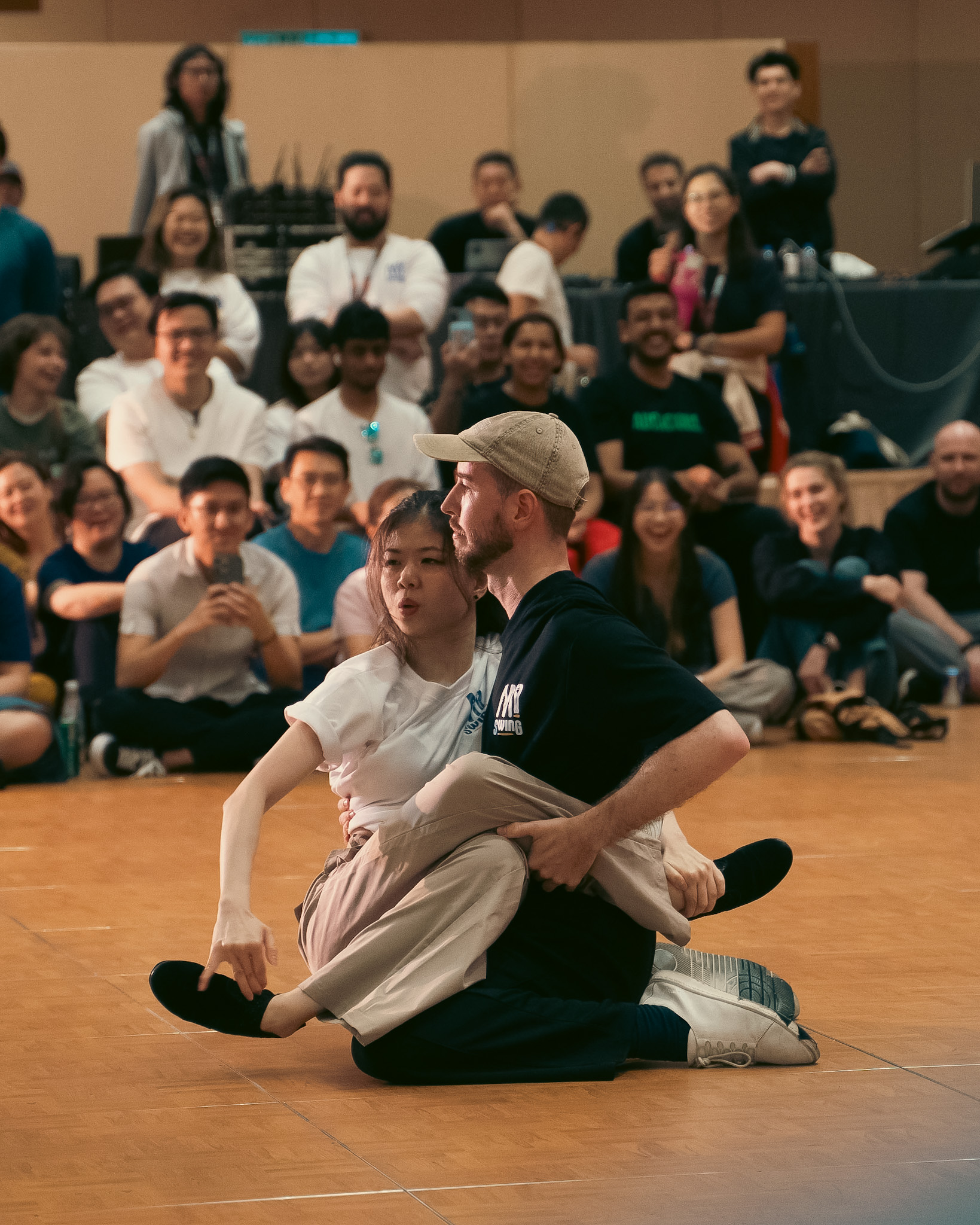 Two dancers settle into a playful floor pose.