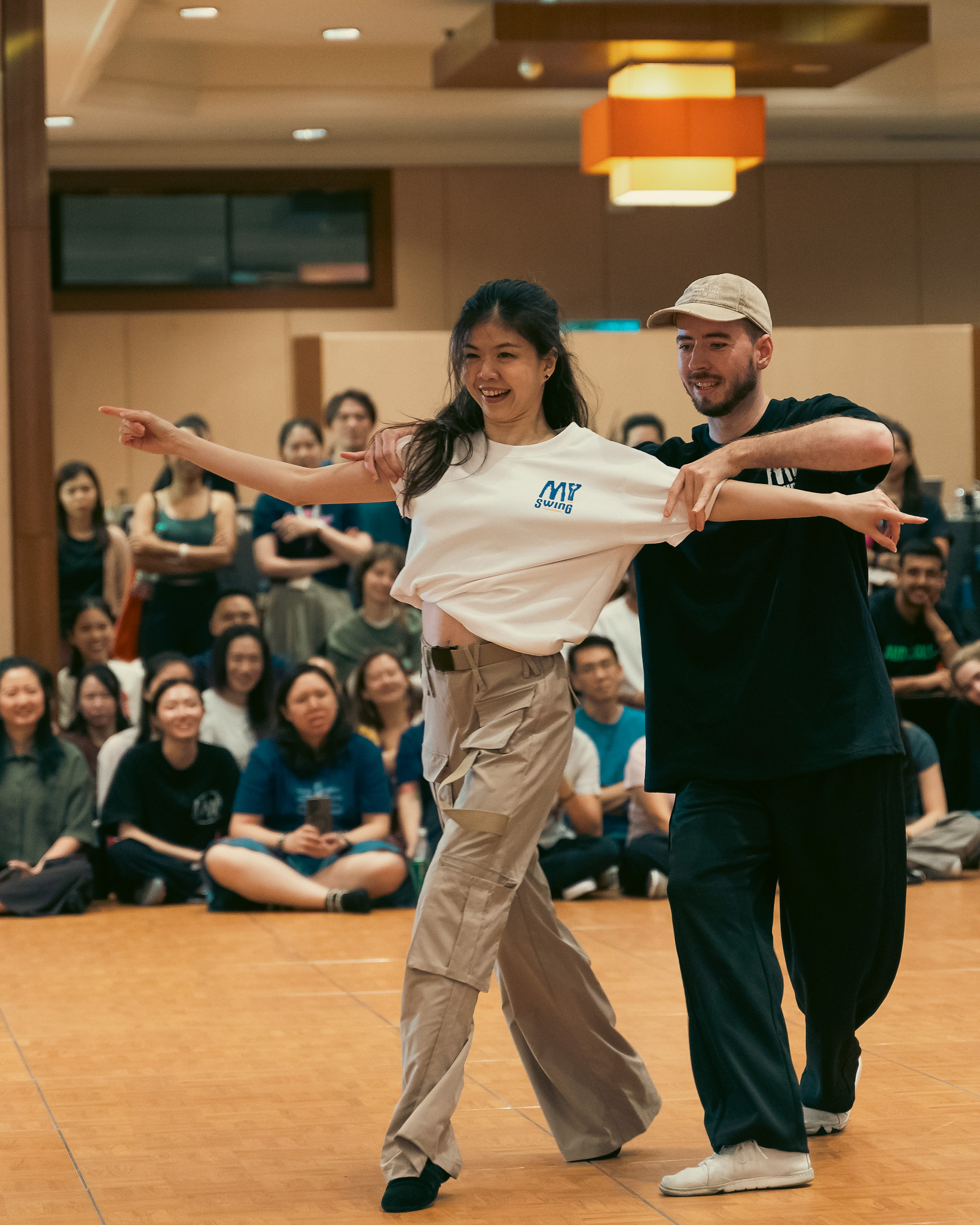 Two smiling Pro Invitational dancers extend their arms together at MY Swing 2026