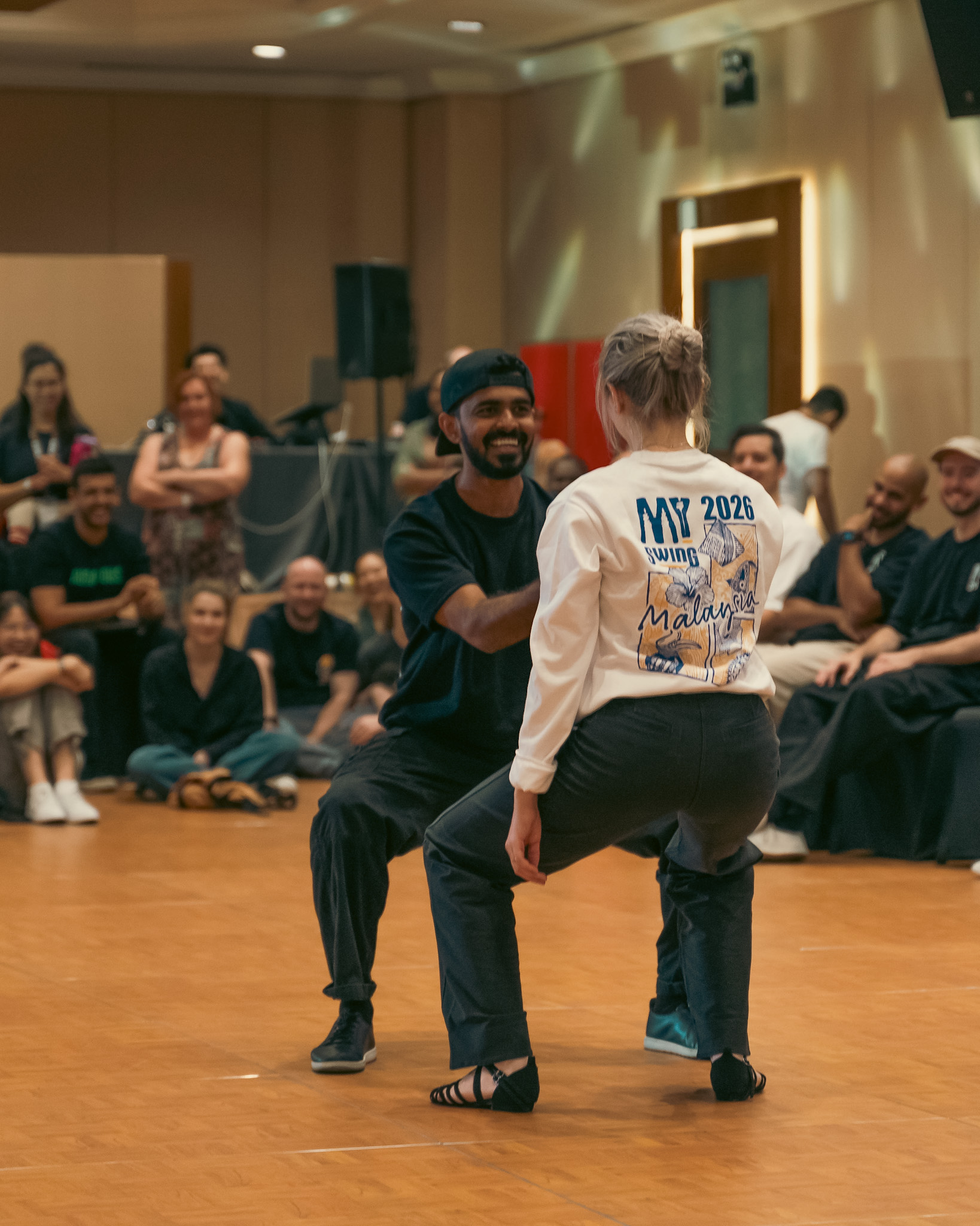 Partners face one another in a playful dance exchange.